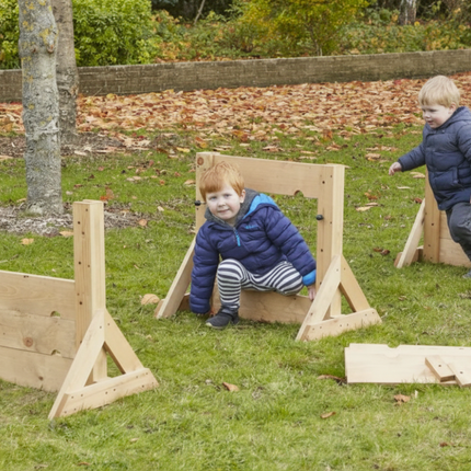 Two children playing with wooden wall in a park