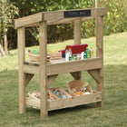 Wooden toy shop set up outdoors with various toys and items on a grassy background.