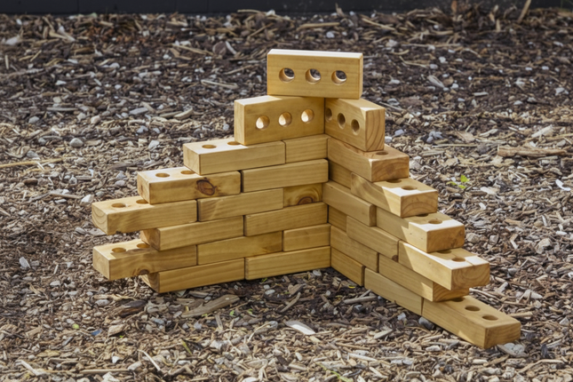 Wooden block sculpture of a bear on a mulched surface