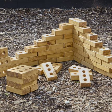 Wooden building blocks arranged in a structure on a dark, textured surface