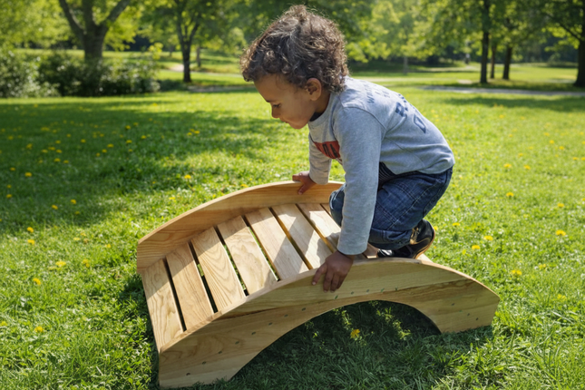 Child playing on a wooden climbing structure in a park