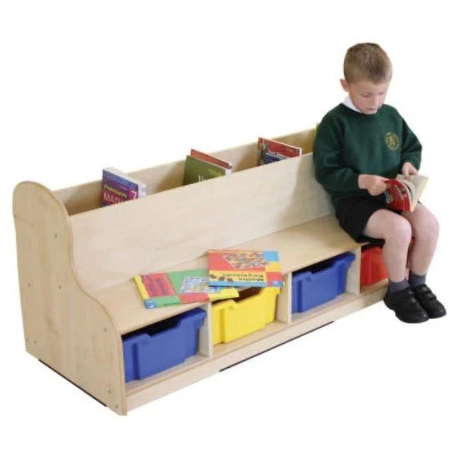 Child sitting on a wooden bench with storage bins and books on a white background