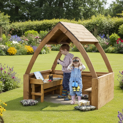 Two children playing inside a wooden playhouse with a brick wall background.