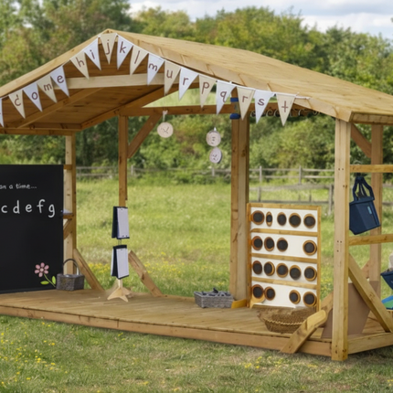 Wooden playhouse with educational items on a grassy field